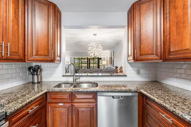 a kitchen with granite countertop stainless steel appliances a refrigerator and cabinets