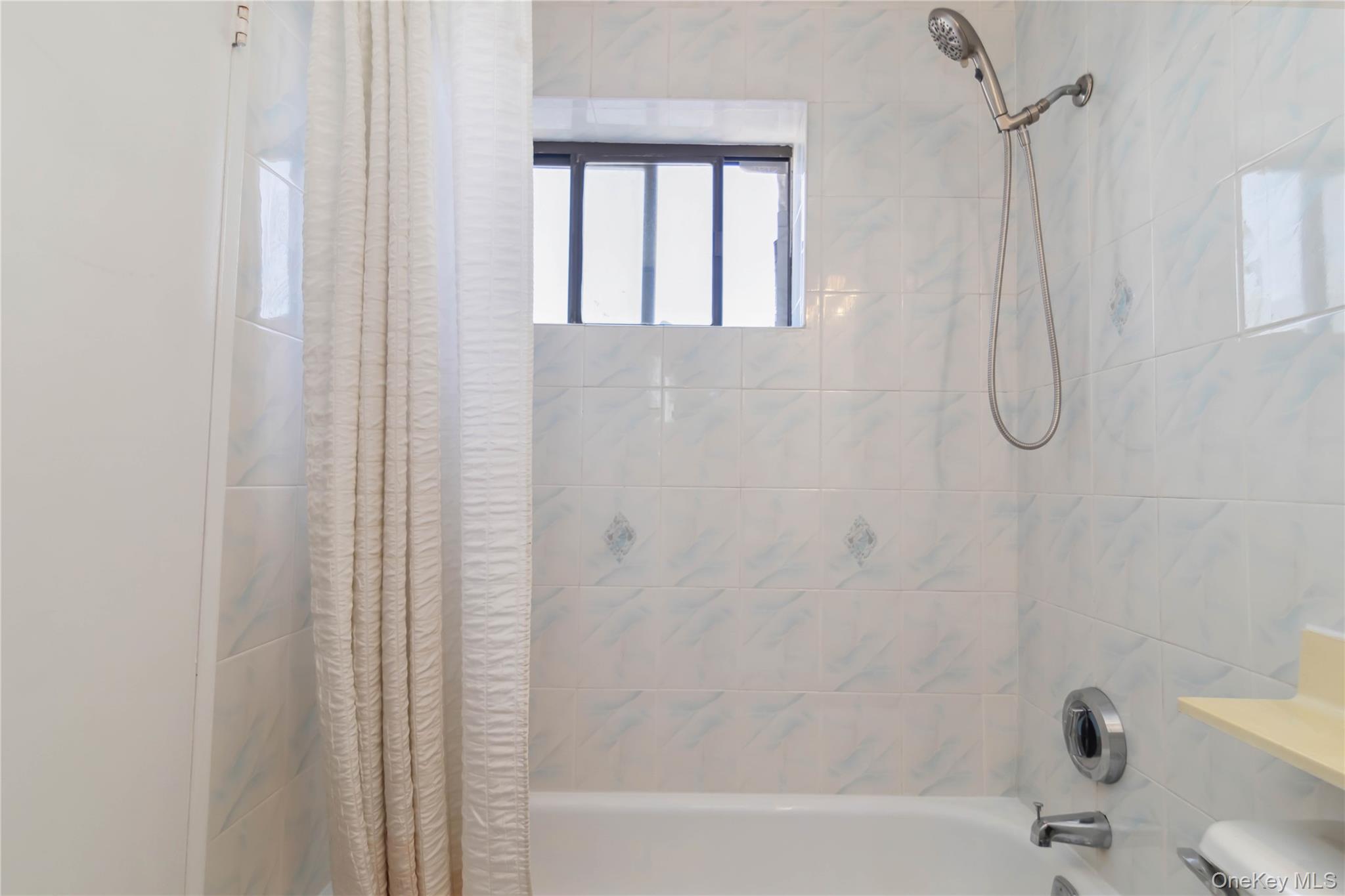23-22 30th Road, Unit 7D Queens, NY 11102 - Photo 17 of 29 Bathroom featuring shower / bath combo with shower curtain