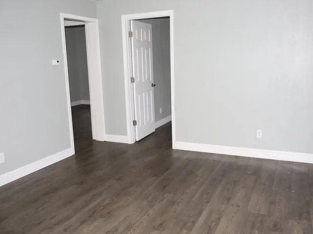 an empty room with wooden floor and closet