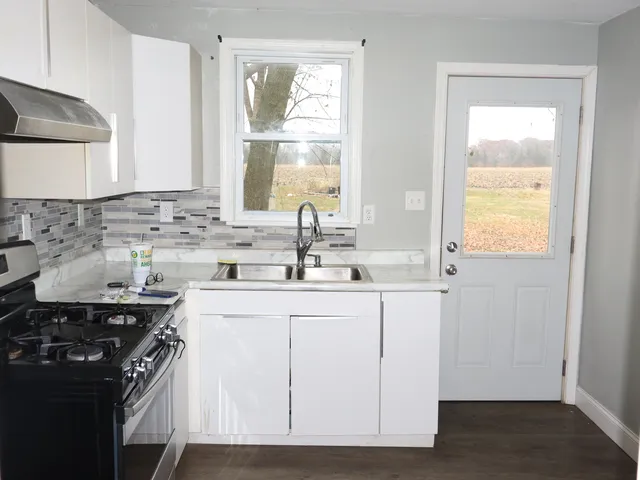 a kitchen with stainless steel appliances granite countertop a sink stove and cabinets