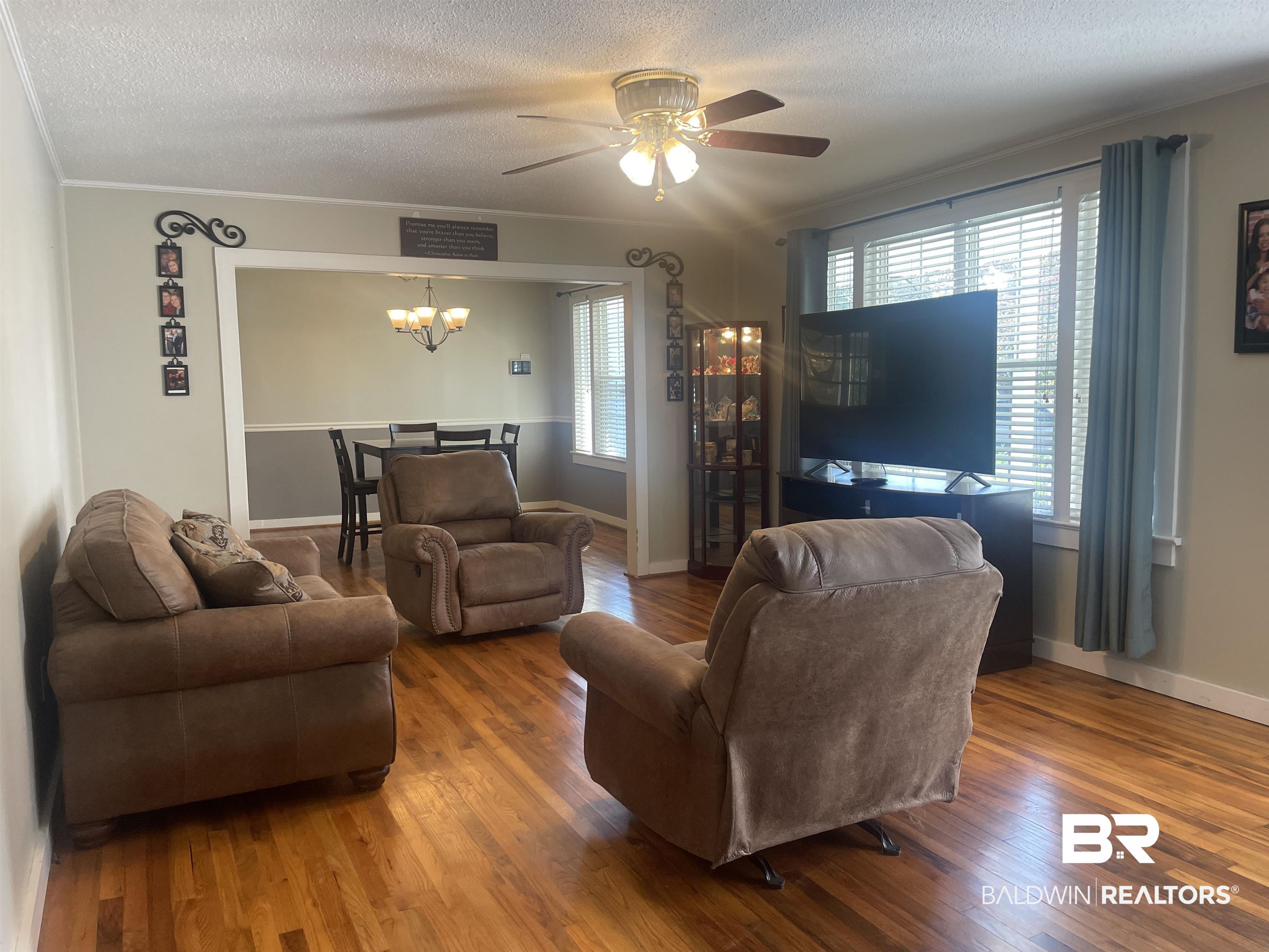 13850 Celeste Road Chunchula, AL 36521 - Photo 5 of 29 Living room with hardwood / wood-style flooring, a textured ceiling, ornamental molding, a ceiling fan, and a chandelier