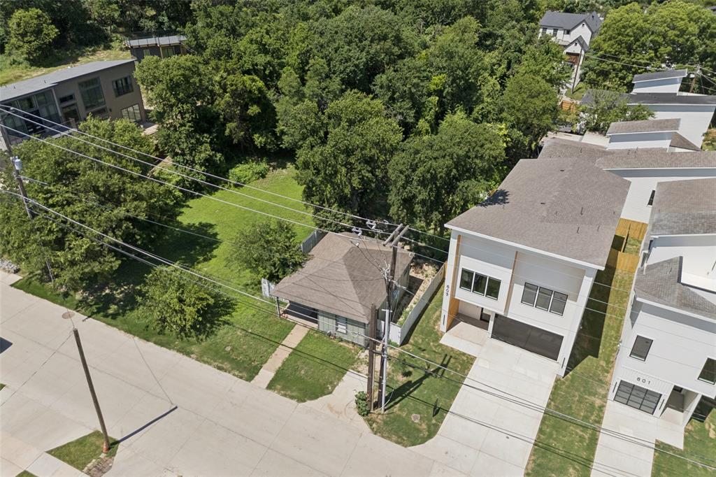 an aerial view of a house with a yard potted plants and large tree