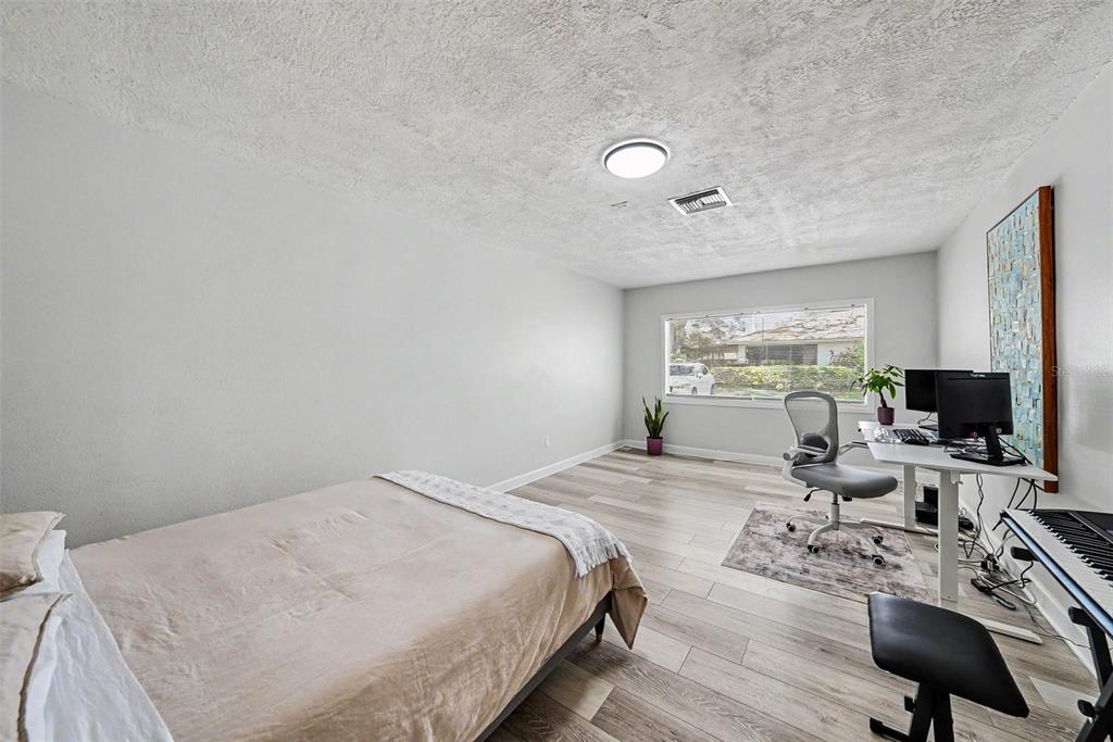 9204 Golf View Drive New Port Richey, FL 34655 - Photo 24 of 33 a bedroom with a bed and wooden floor