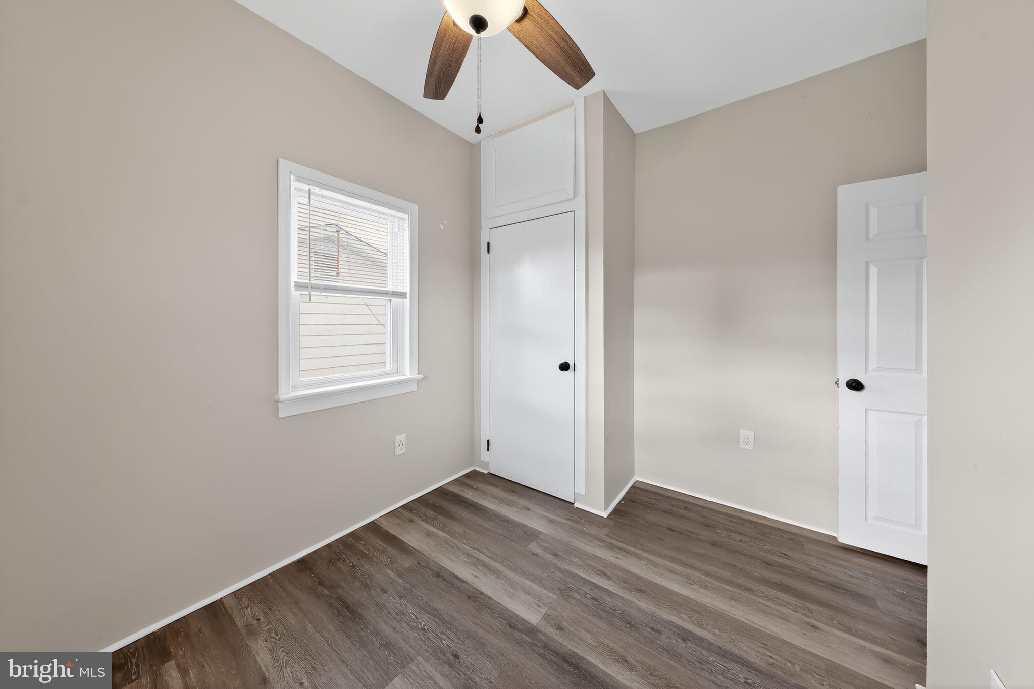 121 Ash Street Carneys Point, NJ 08069 - Photo 17 of 30 an empty room with wooden floor cabinet and windows