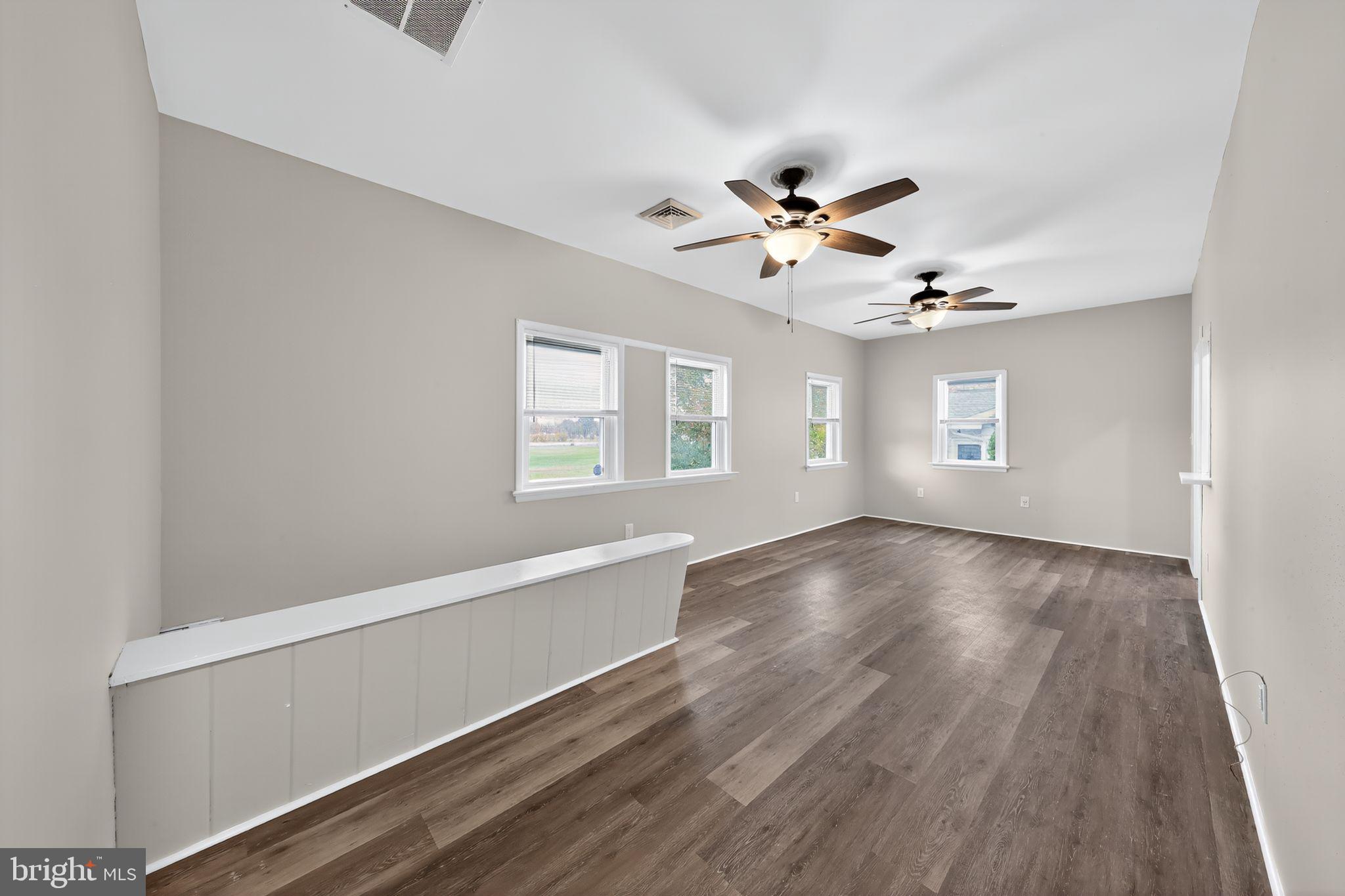 121 Ash Street Carneys Point, NJ 08069 - Photo 8 of 30 a view of an empty room with a window and wooden floor