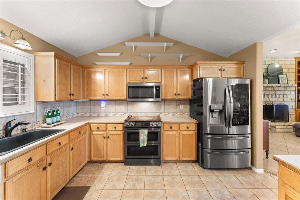 2700 Auction Barn Road Belton, TX 76513 - Photo 9 of 38 a kitchen with stainless steel appliances a refrigerator sink and cabinets