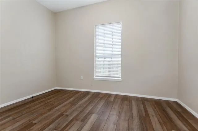 a view of an empty room with wooden floor