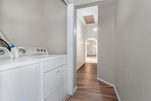 an empty room with wooden floor and a ceiling fan