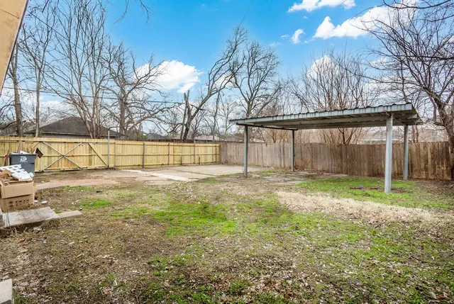 a view of a yard with wooden fence