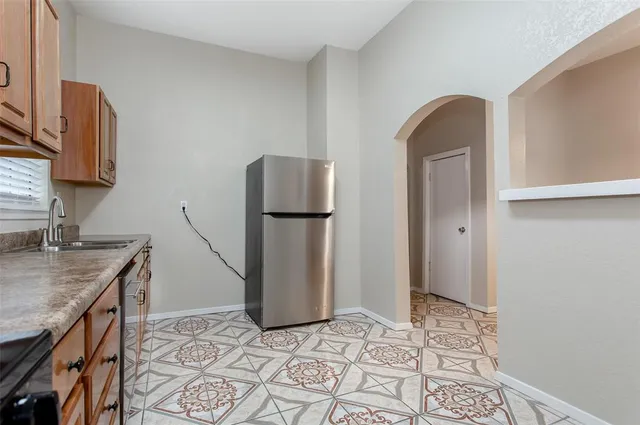 a kitchen with stainless steel appliances granite countertop a refrigerator and a sink