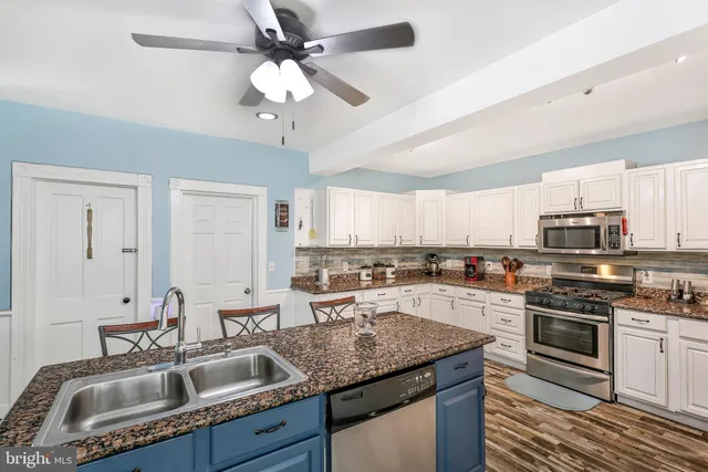 a kitchen with a stove sink microwave and cabinets