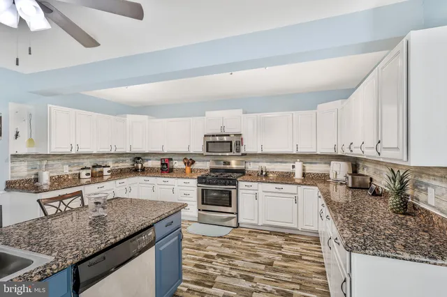 a kitchen with granite countertop a counter space cabinets stainless steel appliances and a counter space