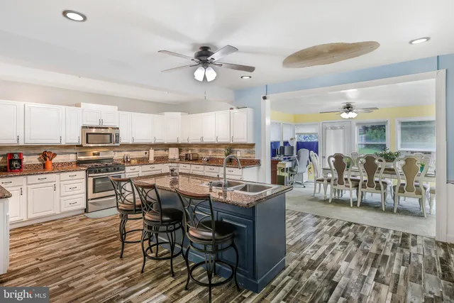 a dining table with chairs and kitchen view