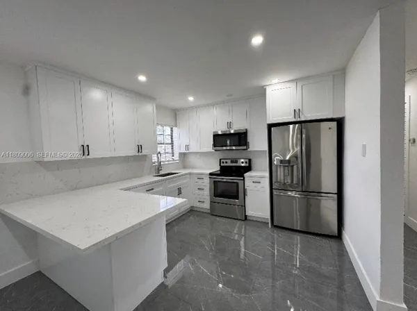 a kitchen with a refrigerator a sink and a oven