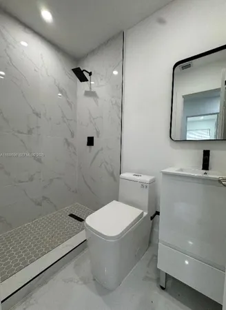 a bathroom with a toilet a sink and shower