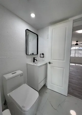 a white toilet sitting next to a bathroom sink