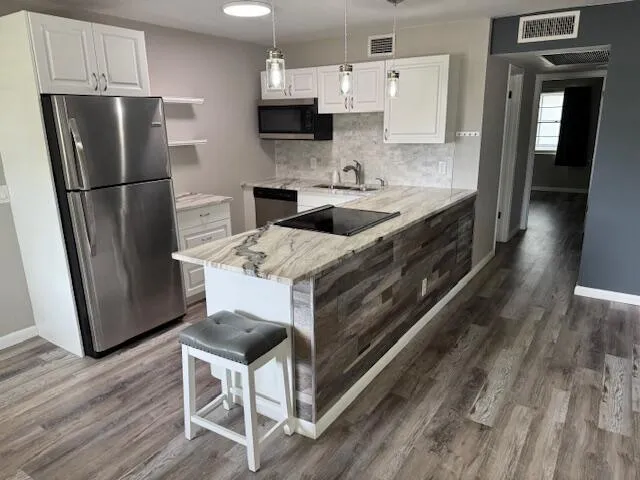 a kitchen with stainless steel appliances a stove refrigerator sink and microwave