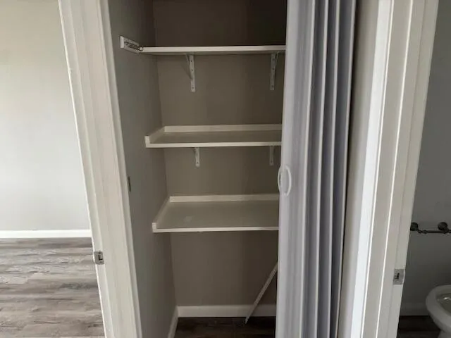 an empty room with wooden floor and closet