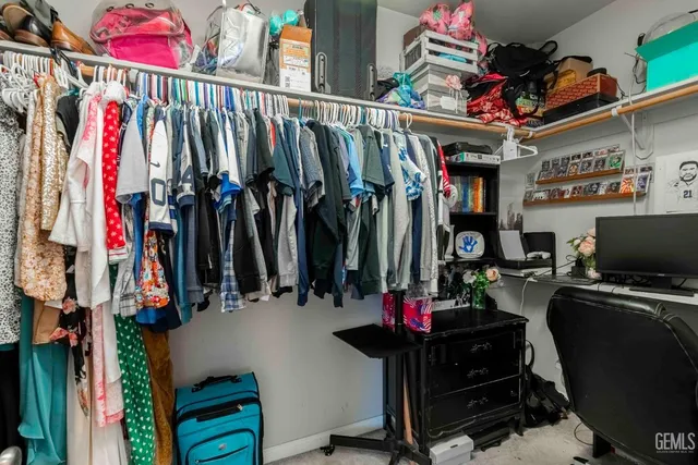 a view of walk in closet with clothes