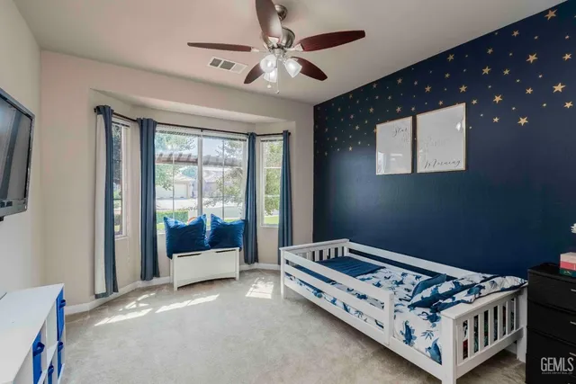 a bed sitting in a bedroom next to a window