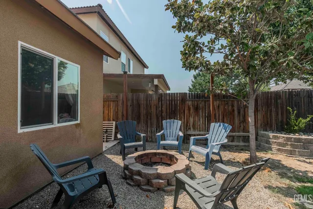 a view of a chairs and table in backyard of the house