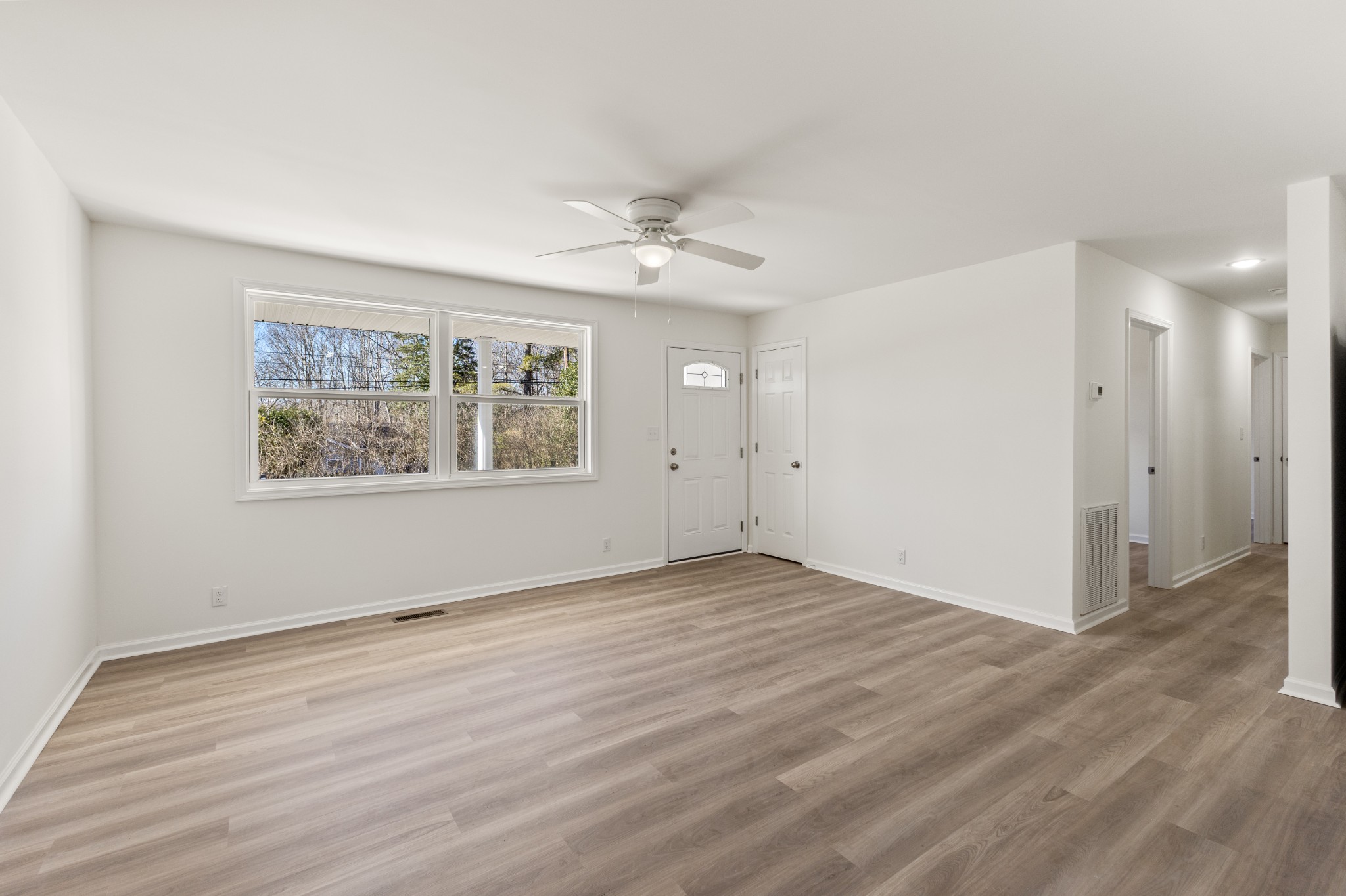 1029 Granada Road Ashland City, TN 37015 - Photo 9 of 34 an empty room with wooden floor ceiling fan and windows