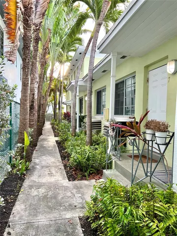 a view of a patio with table and chairs potted plants and large tree