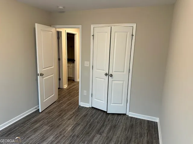 an empty room with wooden floor and entrance