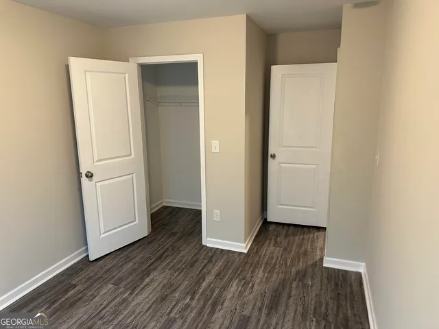 an empty room with wooden floor and white wall