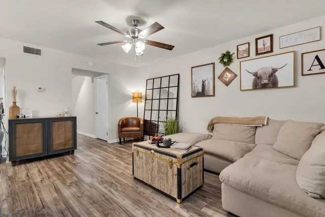 a living room with furniture and a wooden floor