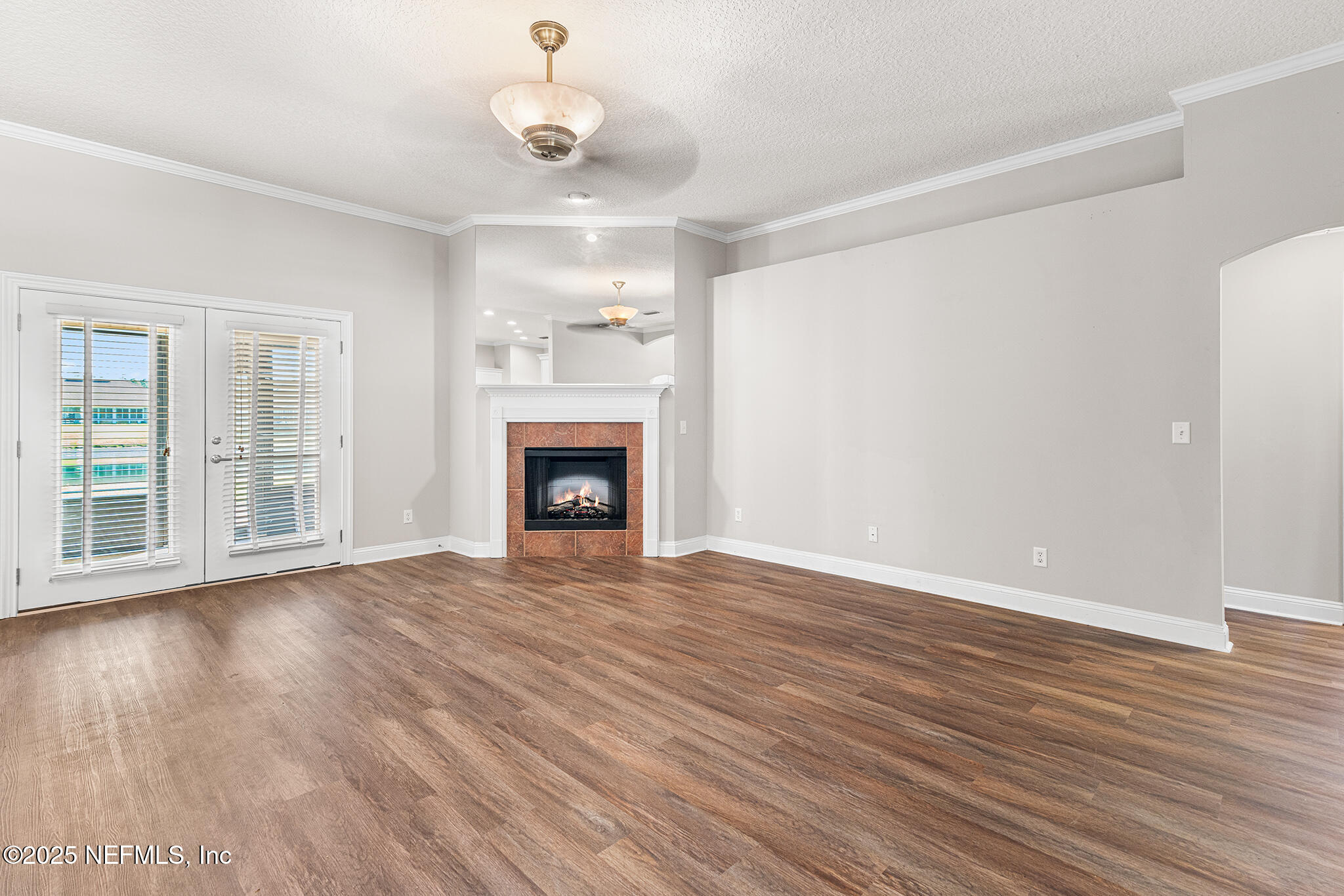 10922 Dunnotar Road Jacksonville, FL 32221 - Photo 8 of 35 an empty room with wooden floor fireplace and windows