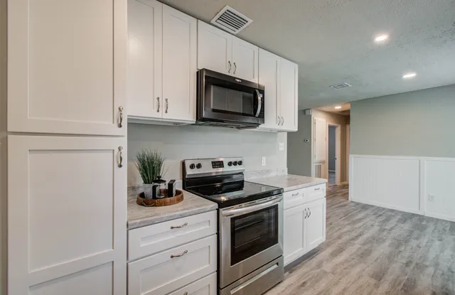 a kitchen with stainless steel appliances granite countertop a stove a microwave and a refrigerator