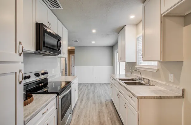 a kitchen with stainless steel appliances granite countertop a stove and a sink