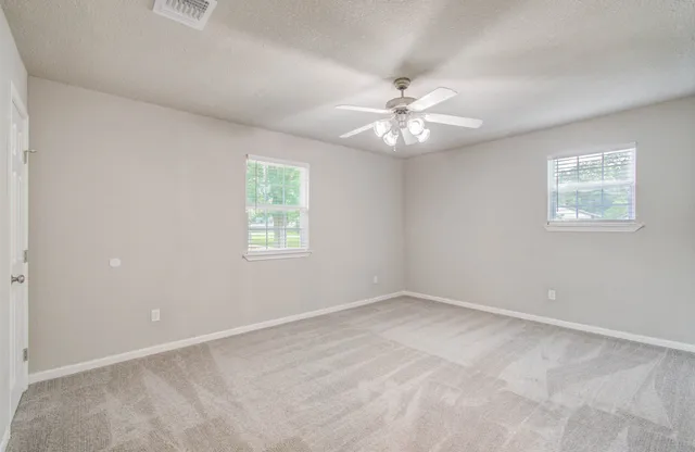 an empty room with chandelier fan