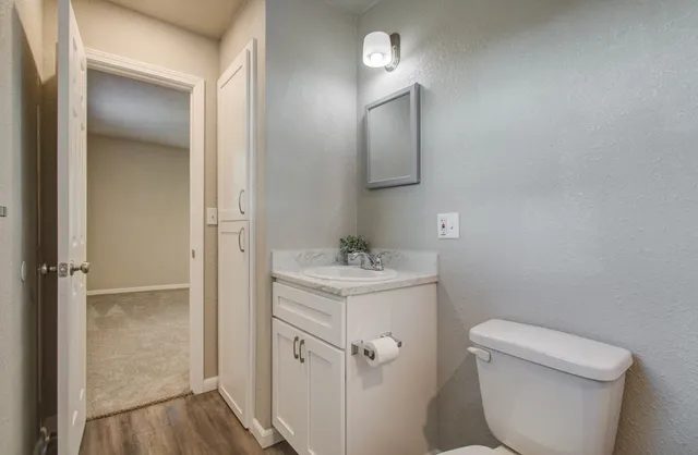 a bathroom with a granite countertop toilet and sink