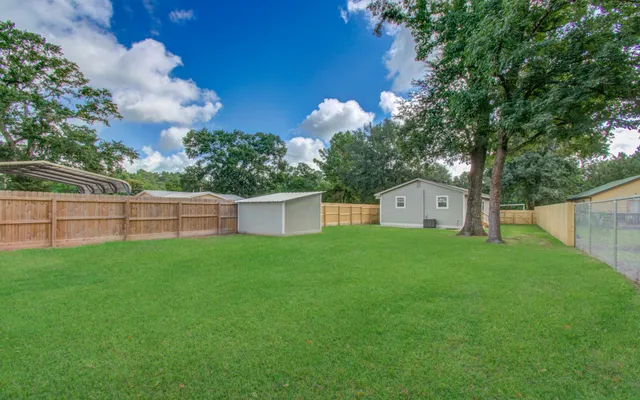 a view of a house with backyard and a tree