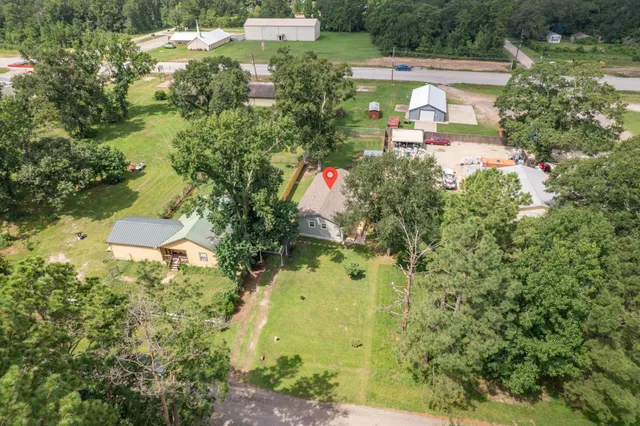 an aerial view of residential house with outdoor space and trees all around
