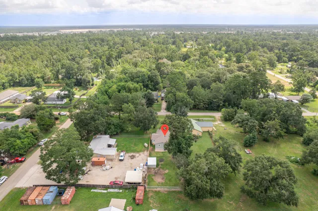 an aerial view of residential houses with outdoor space and trees