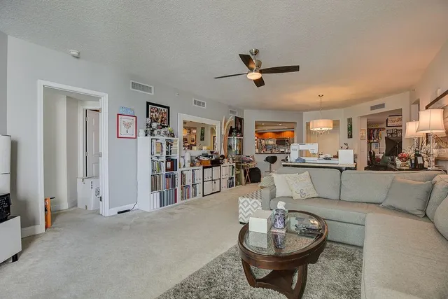 a living room with furniture and a view of kitchen