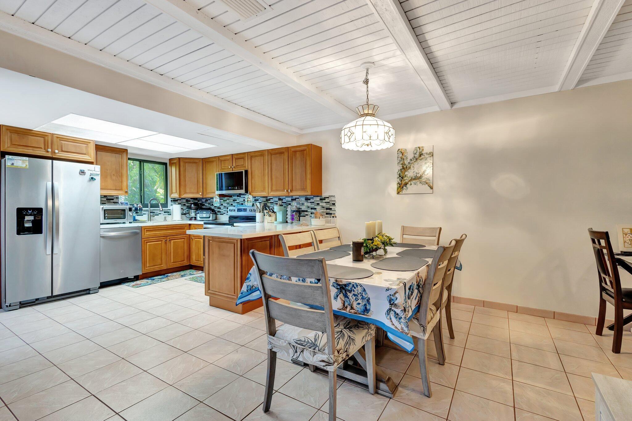 2936 Kirk Road Lake Worth Beach, FL 33461 - Photo 10 of 19 a kitchen with stainless steel appliances kitchen island granite countertop a table chairs and a refrigerator