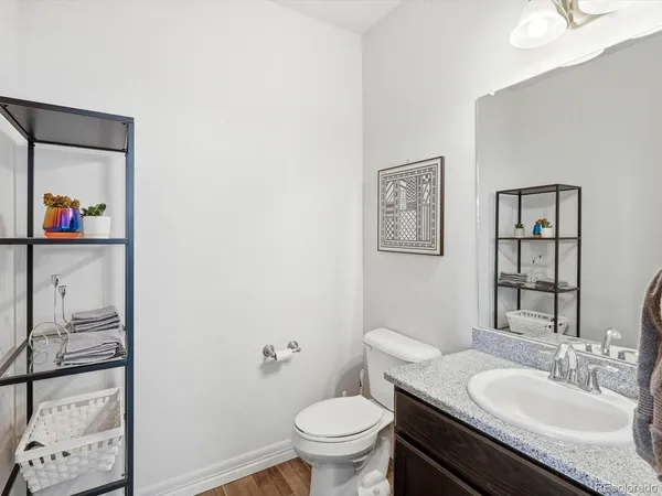 a bathroom with a granite countertop toilet a sink and a mirror