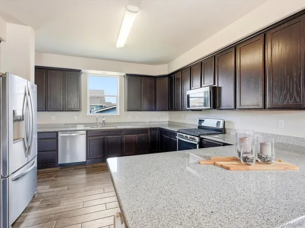 a kitchen with stainless steel appliances granite countertop a refrigerator stove microwave and sink