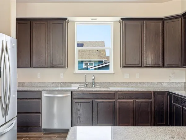 a kitchen with a sink a window and cabinets