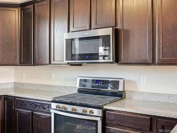 a kitchen with stainless steel appliances granite countertop a stove a microwave and cabinets