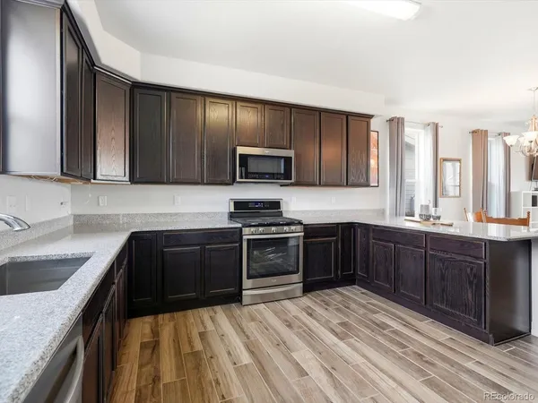 a kitchen with granite countertop wooden cabinets and a stove top oven