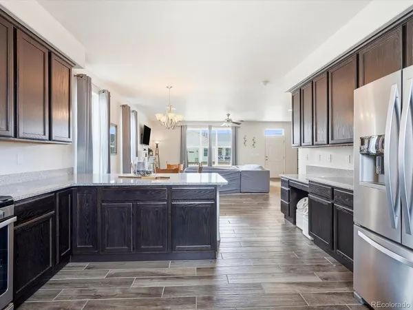 a large kitchen with kitchen island granite countertop wooden floors and stainless steel appliances