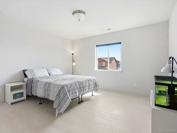 a spacious bedroom with a bed and a tv on the dresser