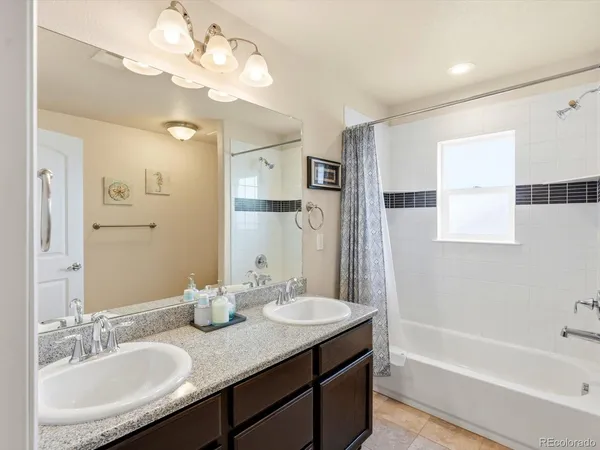 a bathroom with a granite countertop sink a large mirror and a bathtub