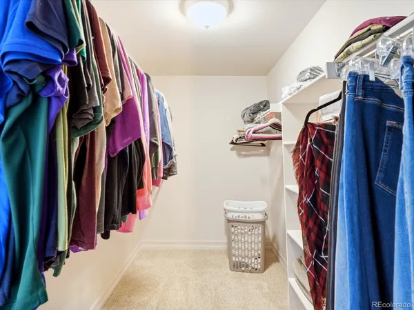 a view of walk in closet with clothes and shoes