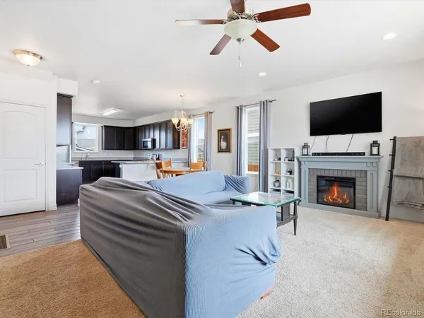 a living room with furniture a flat screen tv and a fireplace